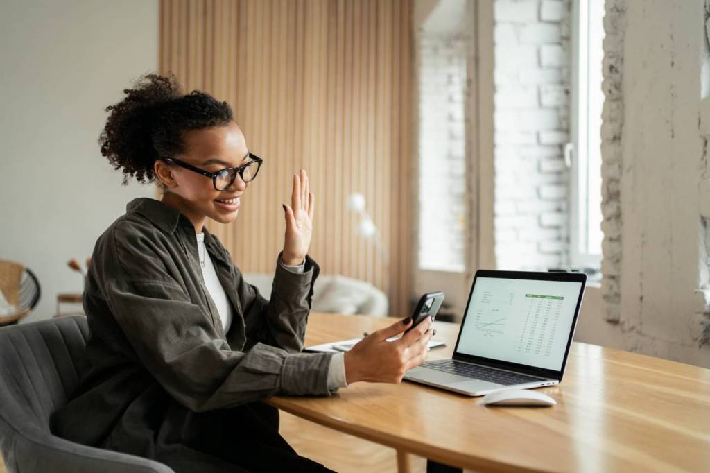A young woman purchases cyber liability insurance online while sitting at a wooden desk